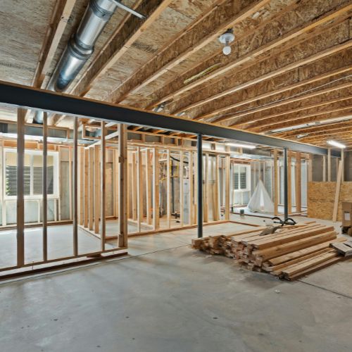 Estructura de madera en construcción con vigas expuestas y materiales almacenados en el suelo